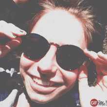 a woman wearing sunglasses is smiling with a gif me logo below her