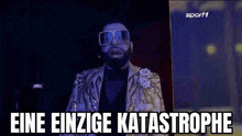 a man in a suit and sunglasses is standing in front of a sign that says eine einzige katastrophe on it .