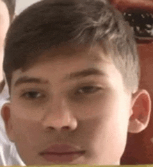 a close up of a young man 's face with a blurred background .