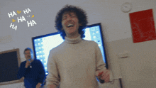 a man with curly hair is laughing in front of a screen that says ha ha ha ha