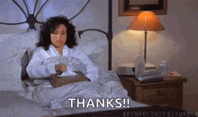 a woman is laying in bed with a napkin in her hand and says thanks !