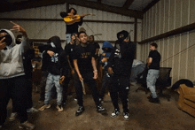 a group of young men are standing in a room holding guns and a guitar .