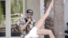 a man singing into a microphone while a woman holds her leg up