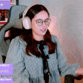 a girl wearing glasses and headphones is sitting in a chair .