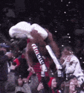 a crowd of people watching a boxing match with a mascot holding a sign that says " chicago "