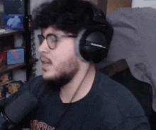 a man wearing glasses and headphones is talking into a microphone ..