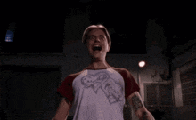 a woman is screaming in a dark room while holding a white cloth in her hands .