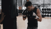 a man wearing boxing gloves that say bx on the front