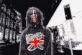 a man with dreadlocks is wearing a black shirt with a british flag on it