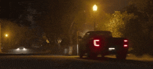 a truck is driving down the street at night