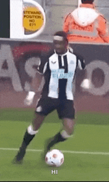 a soccer player is kicking a soccer ball on a field with hi written on the bottom