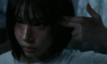 a woman with a bandage on her nose is pointing her finger at herself