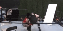 a wrestling match is going on in a ring with a white door in the background