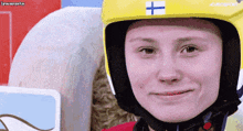 a woman wearing a helmet with a cross on it is smiling