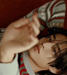 a close up of a person laying on a couch with their hand out