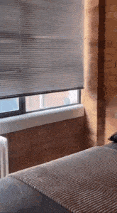 a bedroom with a bed and a window with blinds