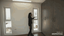 a woman is standing in a room with the words made in animatica above her