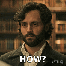a man with a beard says how in front of a bookshelf