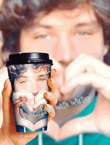 a man is making a heart shape with his hands while holding a cup of coffee that says coffee with whitney