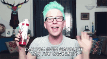 a man with green hair and glasses is holding a candle and asking if he can handle it