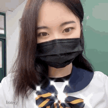 a girl wearing a mask and a bow tie has the word honey written on the bottom right