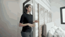 a woman in a black shirt is standing in a room with the words made in animotica on the bottom right