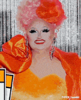 a drag queen wearing a pink and orange wig