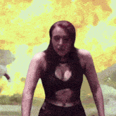 a woman is standing in front of a large fire