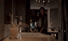a woman stands in front of a bathroom sink looking at herself in the mirror