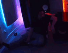 a man is sitting on the floor in a dark room playing a video game