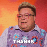a man wearing glasses and a purple sweater says " thanks "