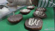 a person is spreading mayonnaise on a bun on a cutting board that says made in animatica