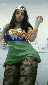 a woman in a wonder woman costume stands in front of a washing machine