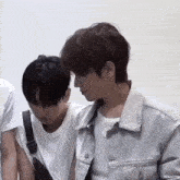 a man in a white shirt is standing next to another man