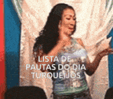 a woman dancing in front of a sign that says lista de pautas do dia turqueijos