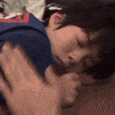 a person is putting their hand on a child 's back while he sleeps .