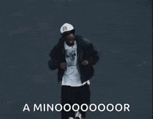 a man wearing a hat and a jacket is dancing with the words a minooooooor written below him