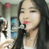 a girl with a microphone in her mouth looks at the camera