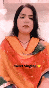 a woman is wearing a red and yellow dress and a yellow scarf .