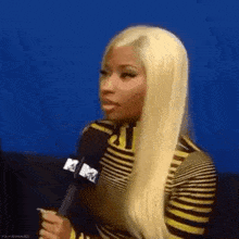 a woman with blonde hair is holding a microphone in her hand .