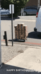 a stack of boxes on a cart with the words `` happy birthday gig ! '' written on the bottom .
