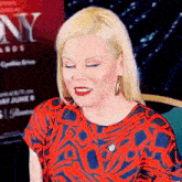 a woman in a red and blue dress is standing in front of a sign that says ny