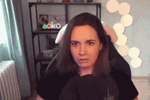 a woman sitting in a chair with a playstation sign in the background