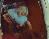 a woman is standing in the trunk of a van holding a gun .