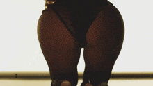 a woman 's butt is shown in black fishnet tights