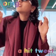 a woman is wearing sunglasses and a red coat and the words omg a hit tweet are above her