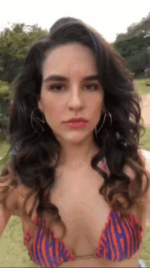 a woman in a bikini is taking a selfie with her phone
