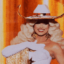 a woman wearing a cowboy hat and white gloves is smiling