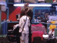 a man and a woman are standing in a room with a lot of shelves .
