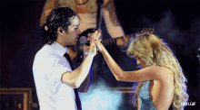 a man and a woman are holding hands in front of a microphone with rbd.gif in the lower right corner